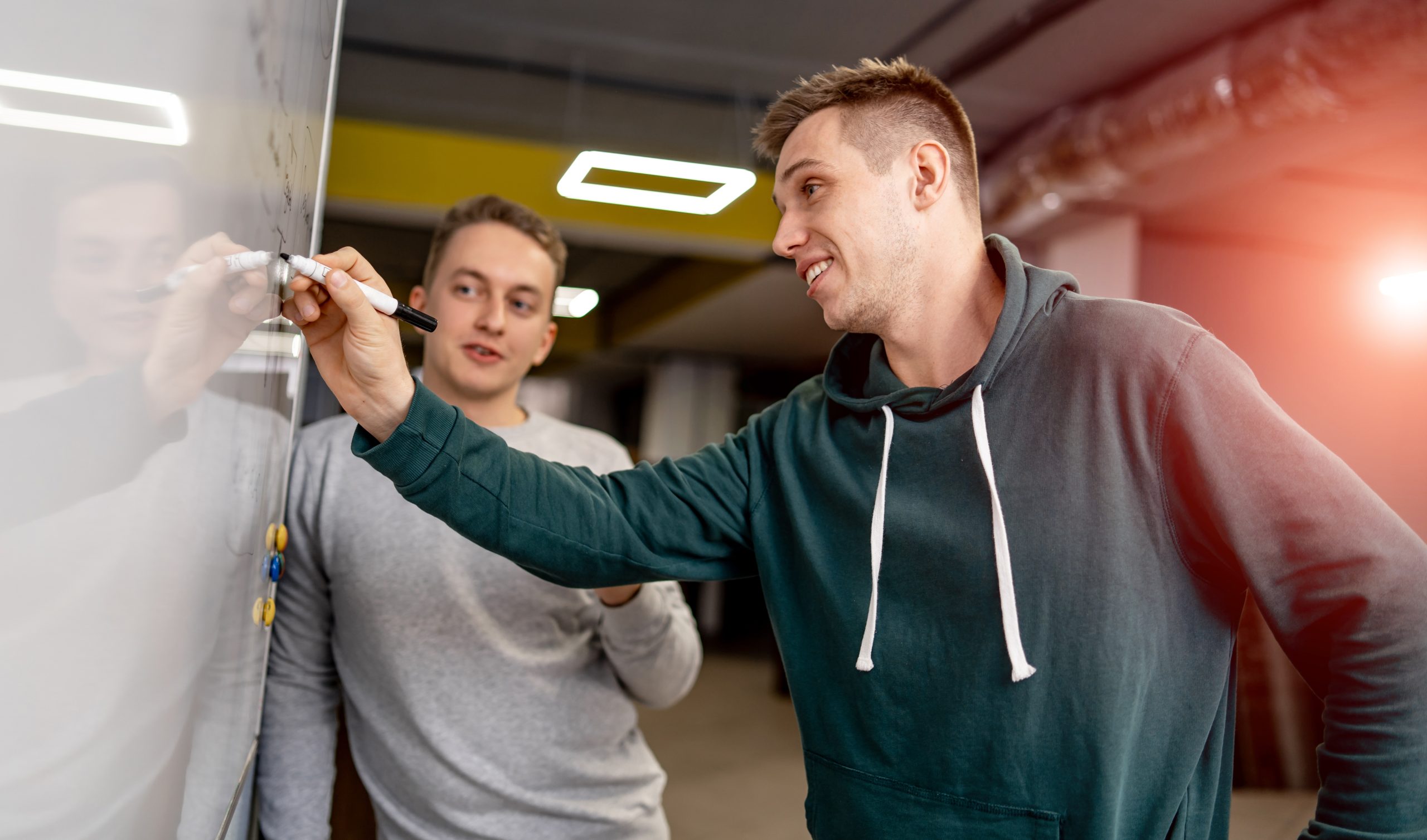 Creative people meeting at office and use post it notes to share idea. Brainstorming concept. Sticky note on glass wall.