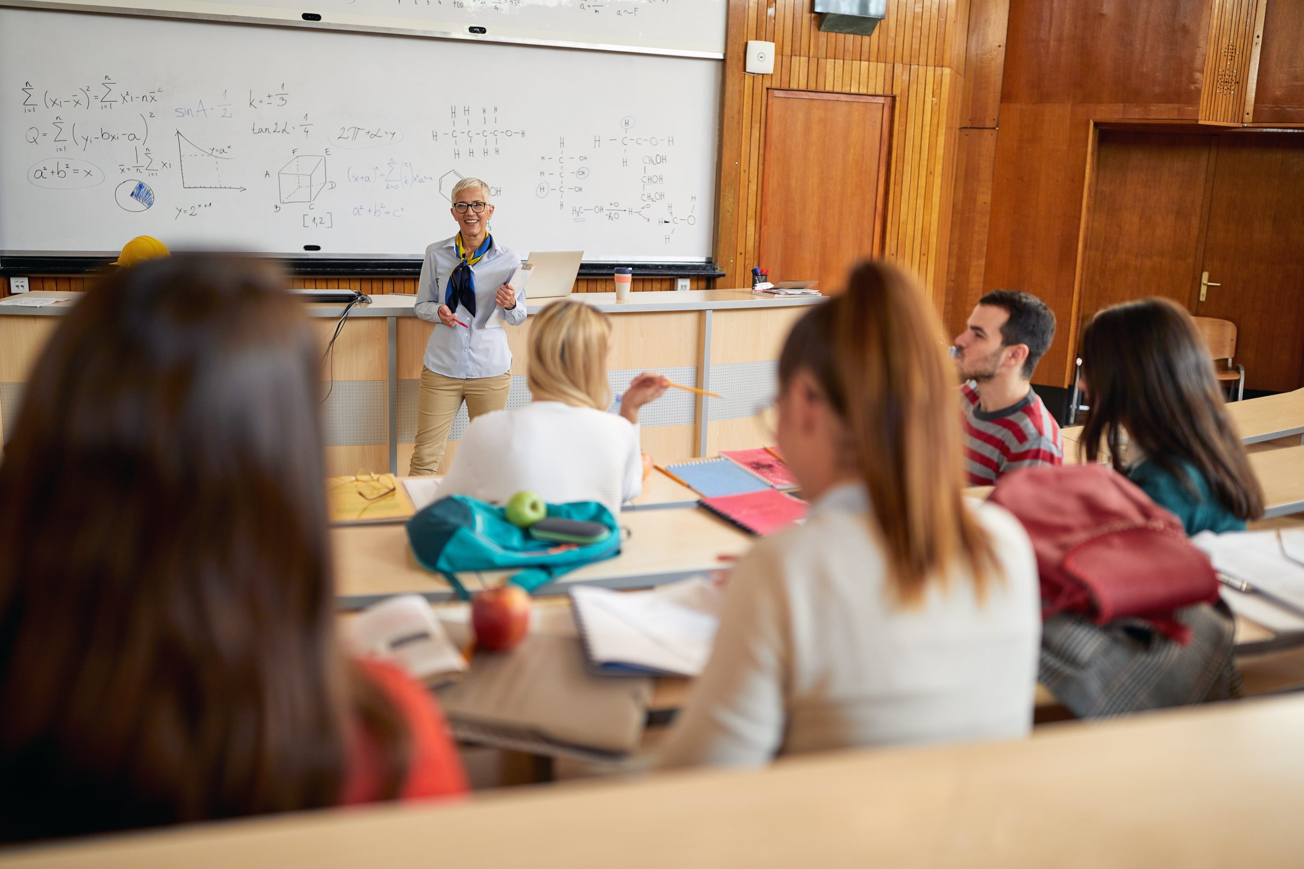 A female professor giving a lecture to students. Smart young peo
